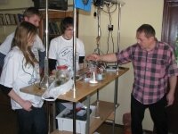 Three students with their teacher experimenting in a physics laboratory Three students with their teacher experimenting in a physics laboratory