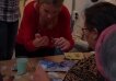 Decoupage workshop for seniors - woman helping an older woman to cut paper